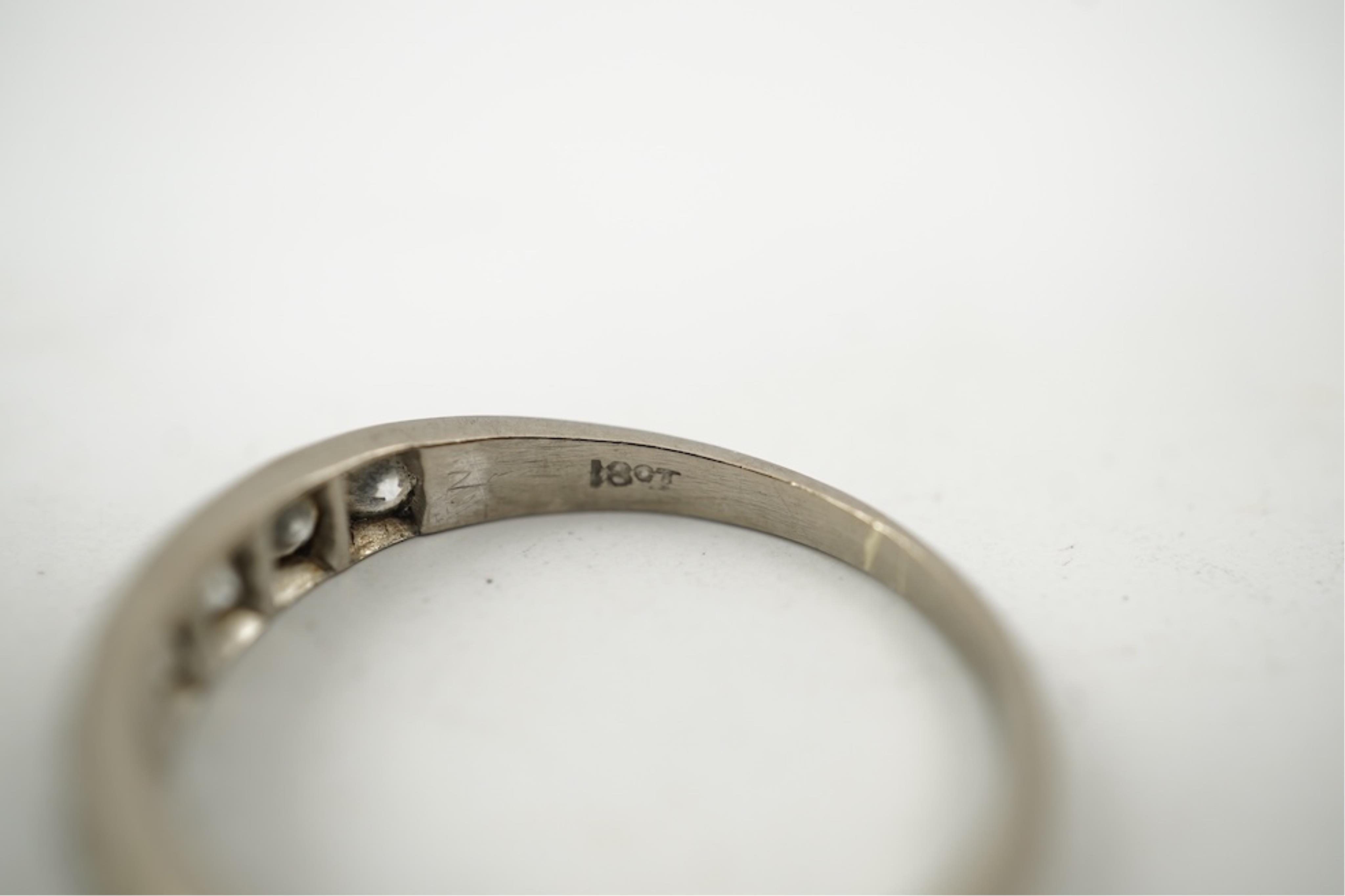 An 18ct white metal and graduated eleven stone diamond set half eternity ring, size P/Q. gross weight 3 grams.